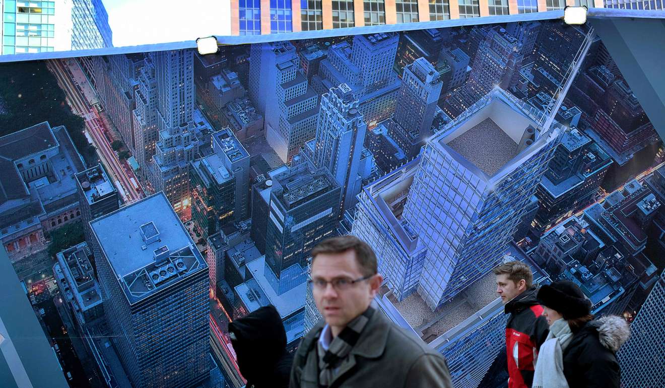 People walk past an advertisement for a high-rise building, around its construction area in New York. Photo: AFP