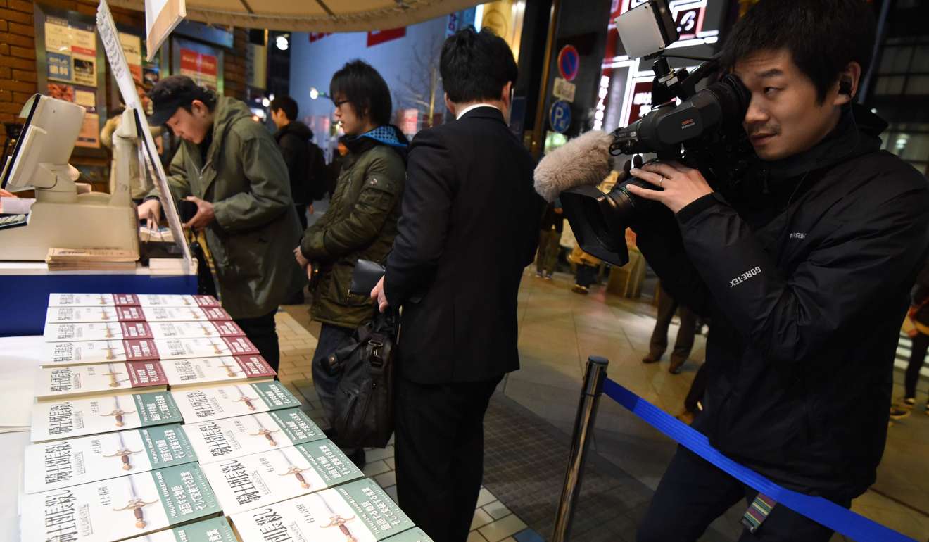 A cameraman films footage as fans of Haruki Murakami, the Japanese author perennially pegged as a contender for the Nobel literature prize, flock to a bookstore in Tokyo. Photo: AFP