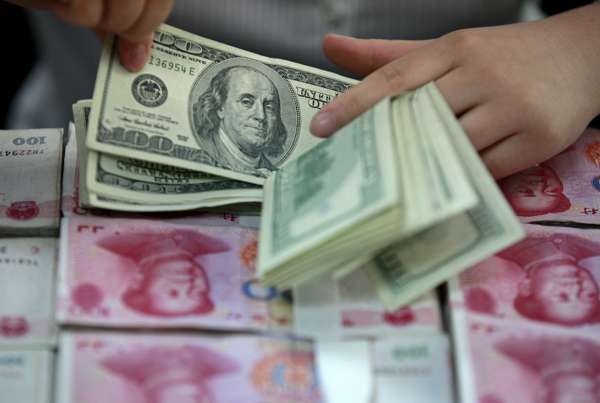 Yuan and US dollar banknotes being counted at a bank in Huaibei, Anhui province. Photo: Reuters