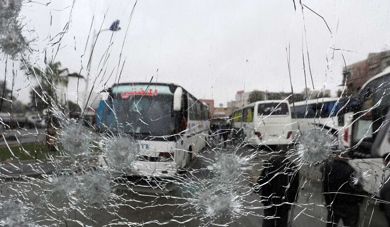 People are seen though a shattered glass window of a bus at the site of the attack. Photo: Reuters