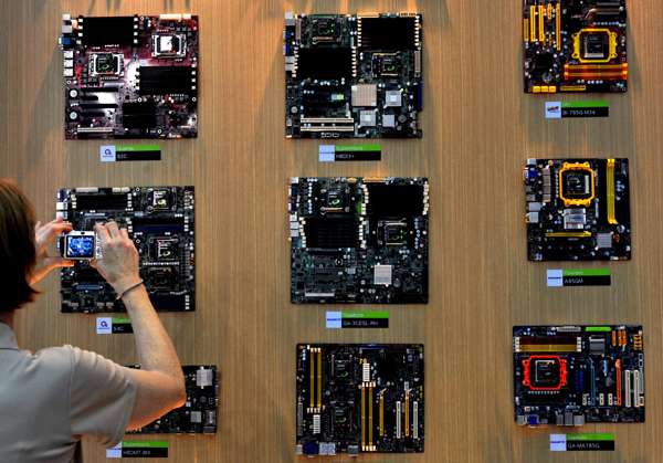 A woman takes a picture of a motherboard during a the Computex 2009 Computex technology trade fair in Taipei. Photo: AFP