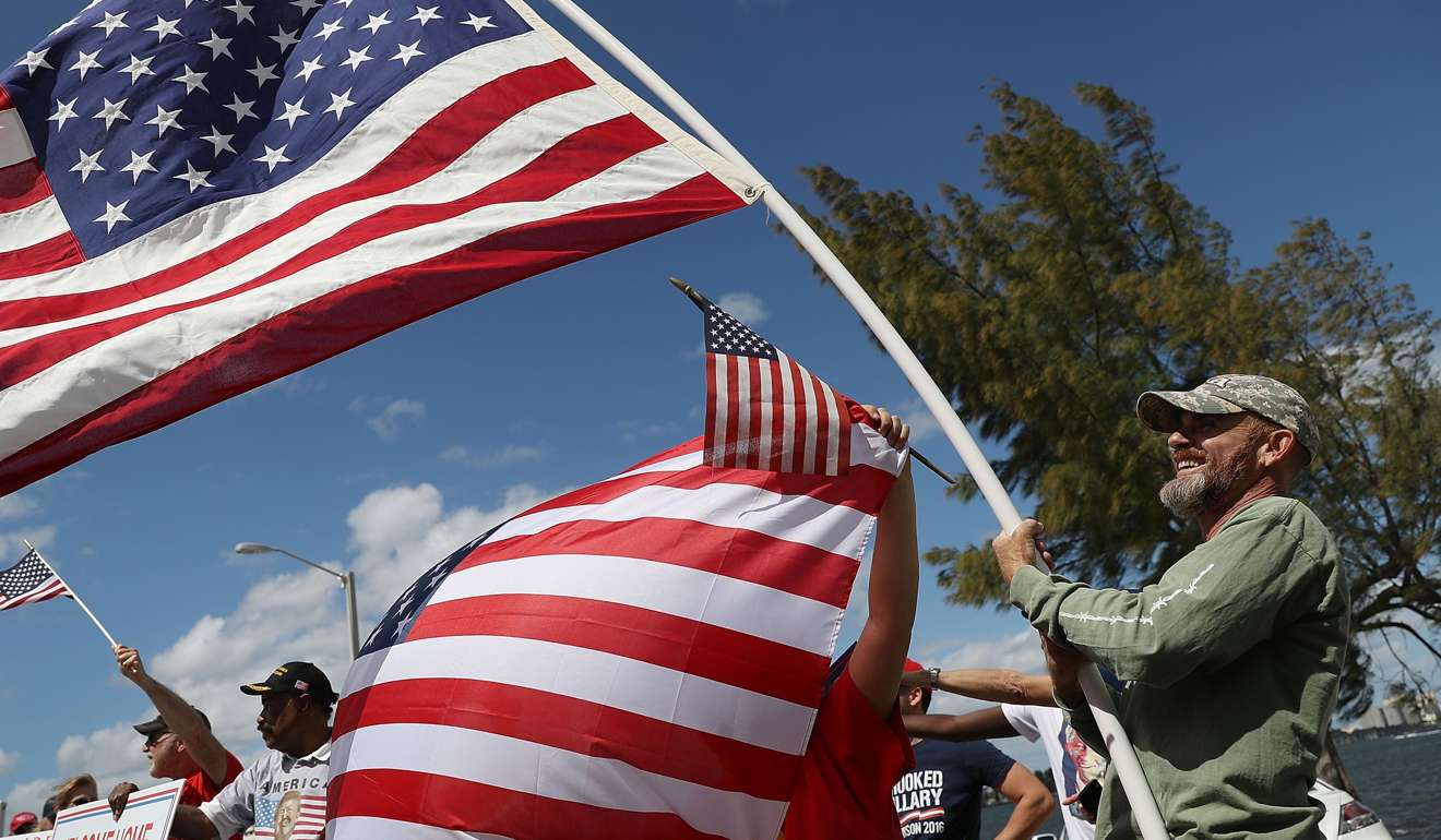 Trump supporter Blake el-Ramey waves the US flag outside Donald Trump’s Mar-a-Lago estate on March 4. Photo: AFP
