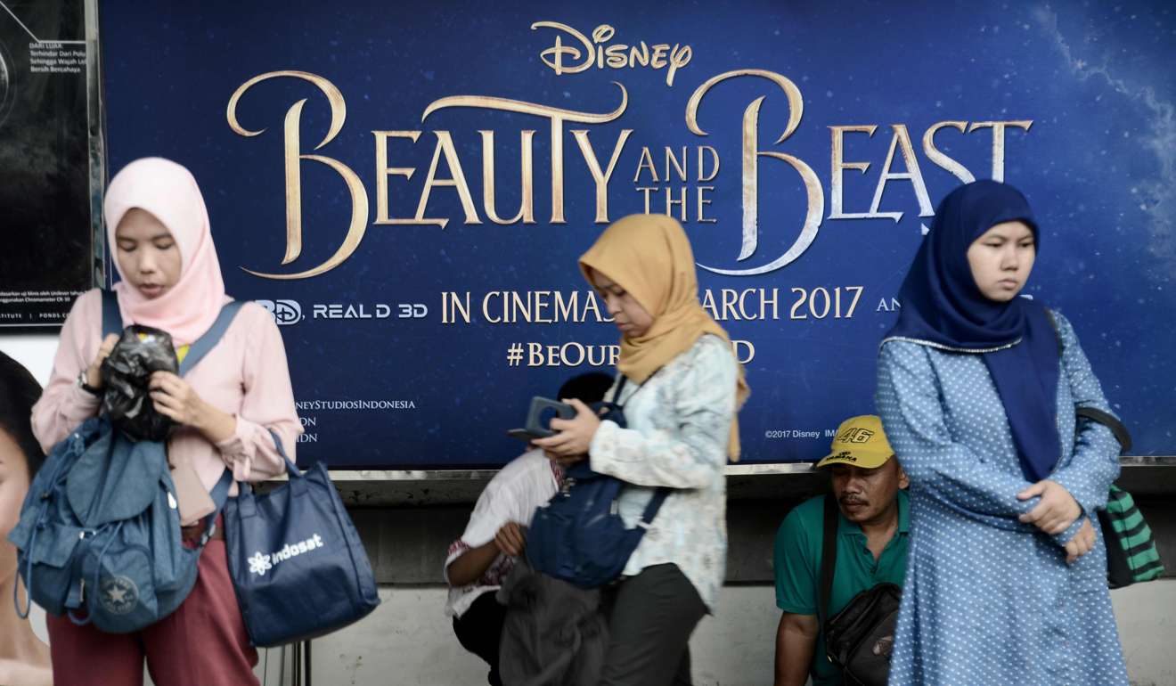 People walk past a poster of Disney blockbuster Beauty and the Beast in Jakarta, Indonesia, on March 30. Photo: AFP