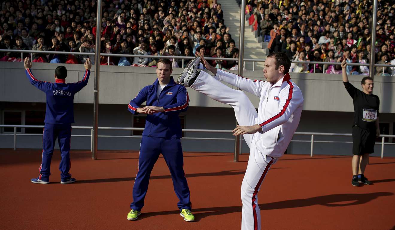 Foreigners dressed in North Korean tracksuits warm up ahead of the Pyongyang marathon. Photo: AP