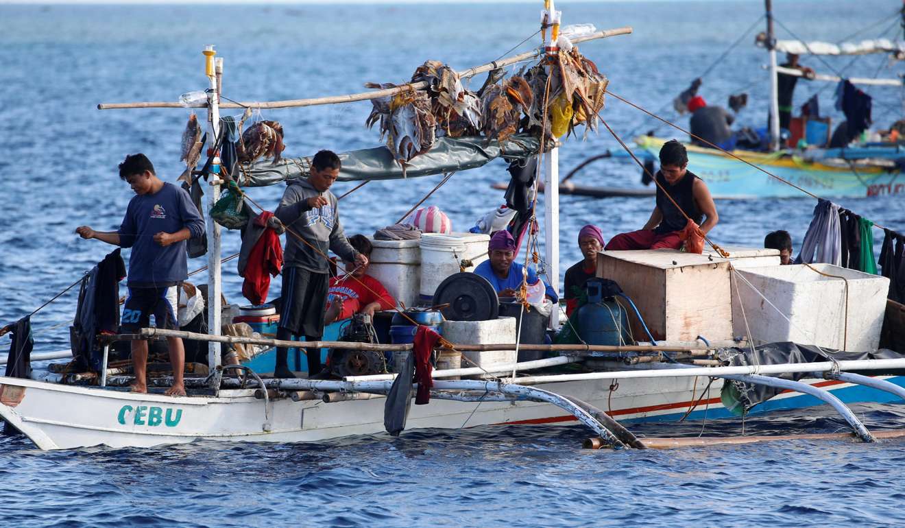 Filipino fishermen rest inside a cramped fishing boat at the shoal. Photo: Reuters