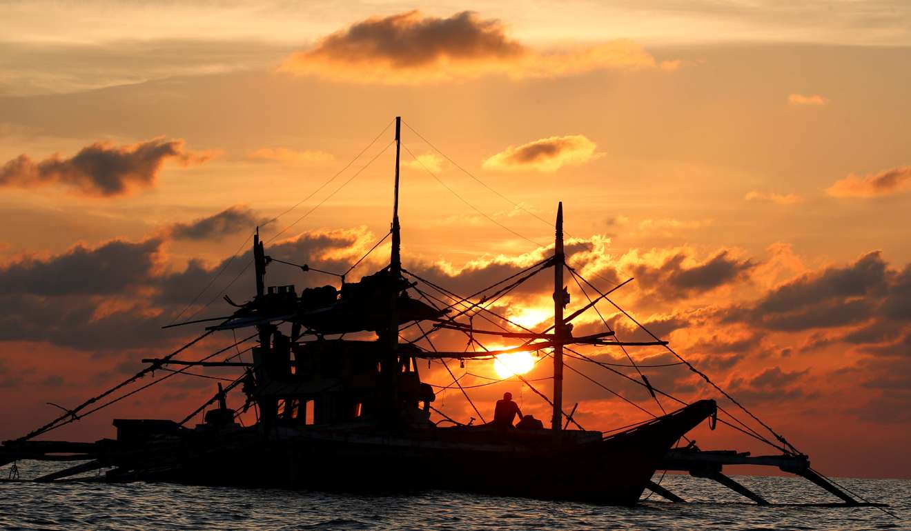 A Philippine boat fishes at sunset at Scarborough Shoal. Photo: Reuters