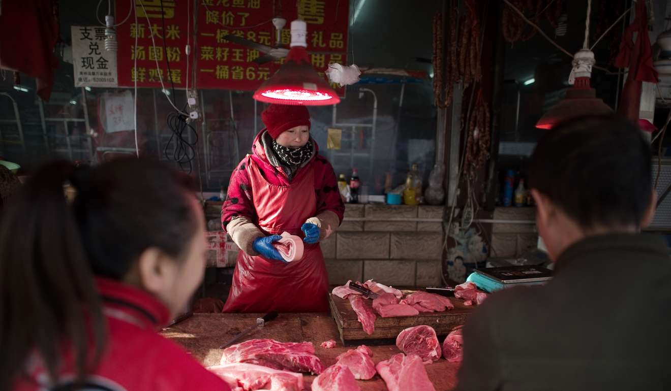 A woman selling meat at a stall in Beijing in January. Photo: AFP