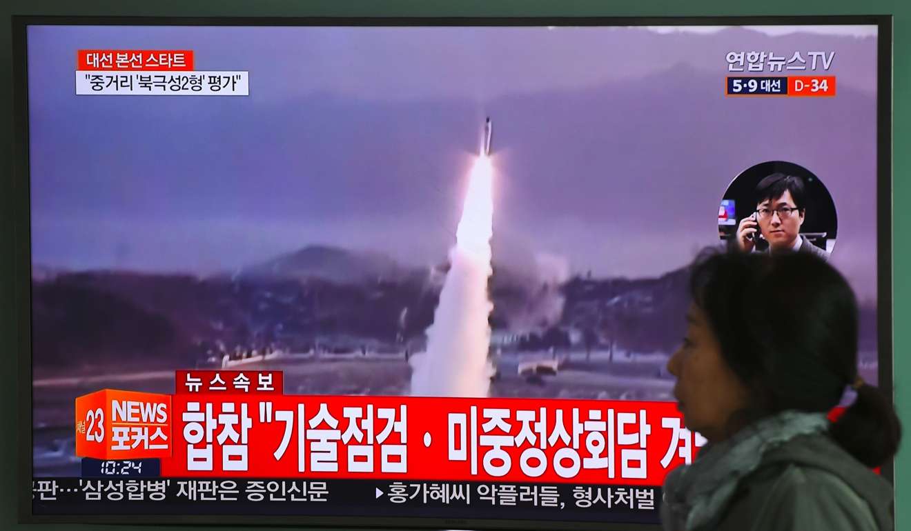 A woman walks past a television screen at a railway station in Seoul last week showing file footage of a North Korean missile launch. North Korea fired a ballistic missile into the Sea of Japan on April 5. Photo: AFP