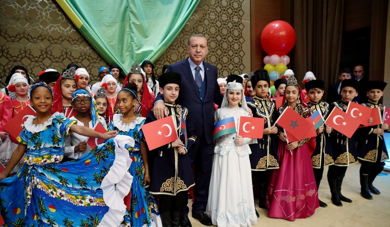 Turkish President Recep Tayyip Erdogan poses with visiting children at the Presidential Palace in Ankara, Turkey. Photo: Reuters