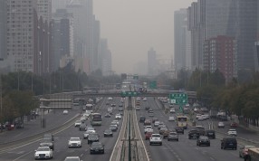 Smog hovers over a main road in Beijing last week. Neighbouring Hebei province has ordered drugmakers to stop production until the smog eases. Photo: EPA