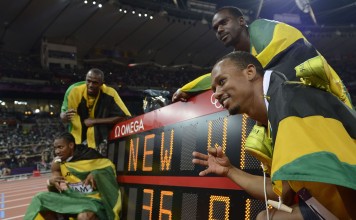 Clockwise from bottom left: Jamaica's Yohan Blake, Usain Bolt, Nesta Carter and Michael Frater pose by the record board after setting a new world record in the men's 4X100 relay final at the London Olympic Games in 2012. Jamaica also won gold in the same race in Beijing four years earlier. Photo: AFP DENNIS