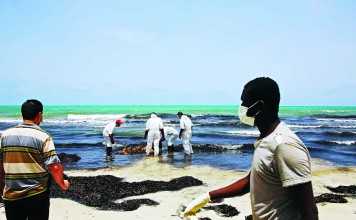 Libyan Red Crescent personnel retrieve the body of a migrant that washed up in the port city of Zuwarah on Thursday. Photo: AFP