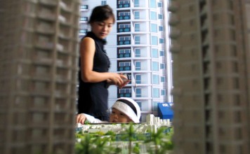 A mother and toddler browse a housing fair in Haikou, in southern Hainan Province. Thirty-two of the 35 cities monitored in a latest survey saw rises in house sales during the first half, with second-tier cities leading the way. Photo: EyePress News.