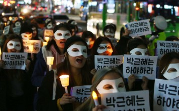 South Korean university students march with candlelight and placards demanding President Park Geun-Hye step down during a protest in Seoul this week. Photo: EPA