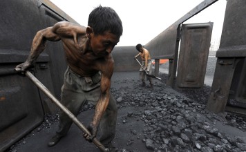 Workers unload coal at a storage site along a railway station in Hefei, Anhui province, China. Photo: Reuters