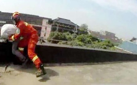A rescuer drags the man back to safety. Photo: Sina.com.cn