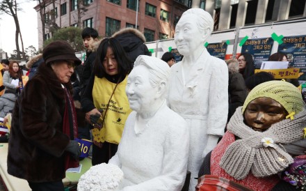 Kim Bok-dong (L), a former ‘comfort woman’, approaches a statue of her. Photo: EPA