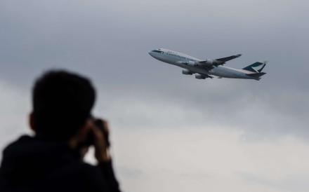 An aviation enthusiast photographs a Cathay Pacific cargo plane as it takes off from the international airport in Hong Kong this month. Symbolically, Cathay is to Hong Kong’s autonomy in the air what the territory’s political and economic institutions are to its special status on the ground. Photo: AFP