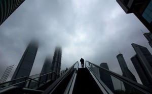 A man rides an escalator in front of high-rise buildings in the financial district Lujiazui in Shanghai. Chinese Premier Li Keqiang says the economy showed signs of improvement in the first quarter. Photo: AFP