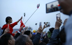 Chinese celebrating National Day on October 1 take photos of the dawn flag-raising ceremony at Tiananmen Square in Beijing. The young adults of the 21st century, along with the technological tools at their disposal, should act as a force of checks and balances in society. Photo: AP