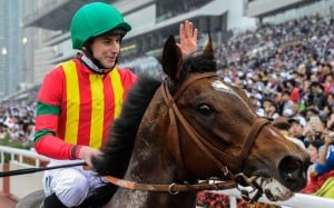 Jockey Ryan Moore of Britain, riding Japanese horse Maurice trained by Noriyuki Hori of Japan, waves to the crowd after winning the Longines Hong Kong Mile race at the Hong Kong International Races at Sha Tin race track in Hong Kong on December 13, 2015. AFP PHOTO / ANTHONY WALLACE