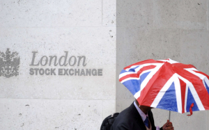A worker shelters from the rain as he passes the London Stock Exchange in the City of London. Photo: REUTERS/TOBY MELVILLE A worker shelters from the rain as he passes the London Stock Exchange in the City of London. Photo: REUTERS/TOBY MELVILLE
