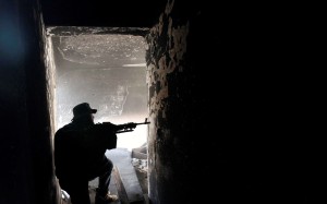 A fighter of Libyan forces aims his weapon as he takes up position inside a ruined house at the front line of fighting with Islamic State militants in Ghiza Bahriya district. Photo: Reuters
