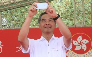 Chief Executive Leung Chun-ying takes some pictures on his phone at the graduation ceremony for military summer camp for HK youth in San Wai Barracks in Fanling.Photo: David Wong