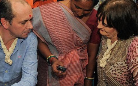 Cherie Blair (R), wife of former British prime minister Tony Blair and chairperson of the Cherie Blair Foundation for Women, and Vodafone Foundation's global director Andrew Dunnett are briefed on a mobile application during their visit to an agricultural processing centre in India. Photo: Sam Panthaky/AFP