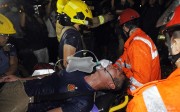 An injured fireman battling the blaze inside the industrial building is rushed into an ambulance yesterday. Photo: SCMP Pictures