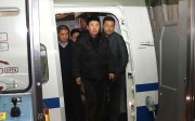 Wanted fugitive Yan Yongmin is escorted off a flight at Capital International Airport, Beijing, on Saturday. Photo: Xinhua