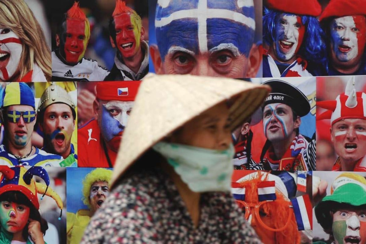 A cyclist in Hanoi rides past an advert for a European football tournament. Illegal gambling, such as on football competitions, is popular in Vietnam. Photo: AFP