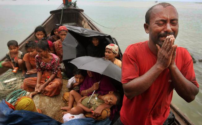 This man, with fellow Rohingya Muslim refugees, pleads for help after their boat was intercepted by Bangladeshi border guards. Photo: AP