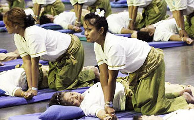 Thai masseuses perform mass massaging at a sports arena on the outskirts of Bangkok. Photo: AP