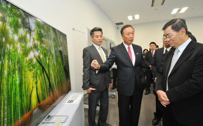 Hon Hai chairman Terry Gou (centre) visits a Sharp plant in Sakai, Japan. Photo: AFP
