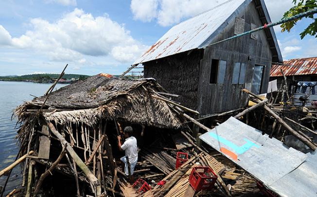 A resident fixes his damaged home after an earthquake hit the town of General MacArthur, eastern Samar province, in the central Philippines. Photo: AP