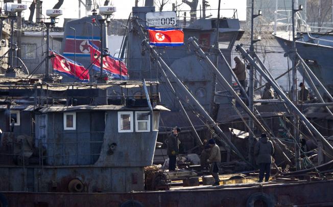 North Koreans work on ships docked along a river bank in Sinuiju, North Korea, opposite to the Chinese border city of Dandong. Photo: AP