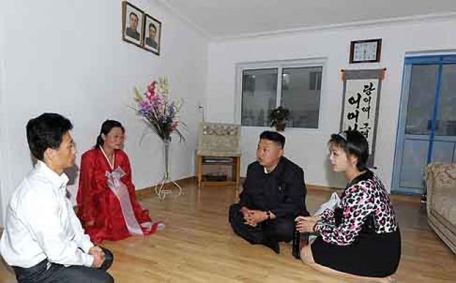 North Korean leader Kim Jong-un (centre, with wife Ri Sol-ju on the right) visits a family in Pyongyang. Photo: EPA
