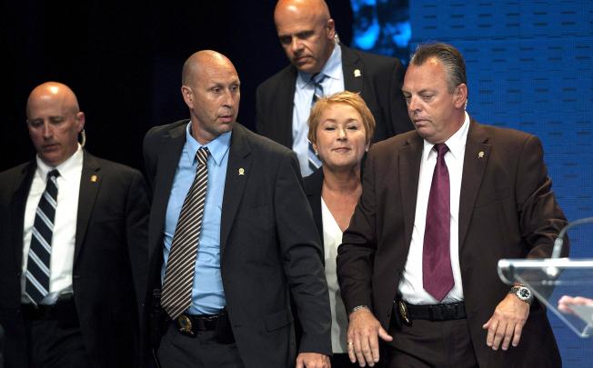Parti Quebecois leader Pauline Marois (centre) is surrounded by police after shots rang out during her victory speech in Montreal on Wednesday. Photo: AP
