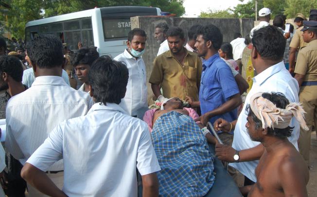 People gather around a dead body to be identified at a cracker factory in Tamilnadu on Wednesday. Photo: Xinhua