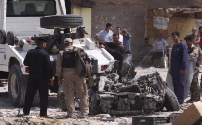 Iraqi policemen inspect the wreckage of a car used in a bomb explosion in the southern port city of Basra. A series of bombs ripped through mainly Shi’ite Baghdad districts on Sunday - with more than 100 killed across the country. Photo: AFP