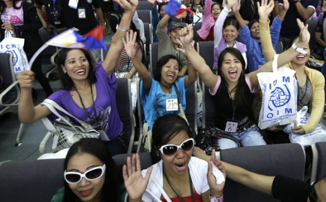 Overseas Filipino Workers, who fled the civil war in Syria, cheer upon arriving at the Ninoy Aquino International Airport on Tuesday. Photo: AP