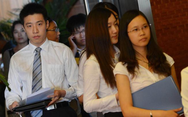 Graduates at a job fair. Job stability is at risk due to a slowing economy, with last month's imports falling and industrial output rising the least in three years. Photo: AFP