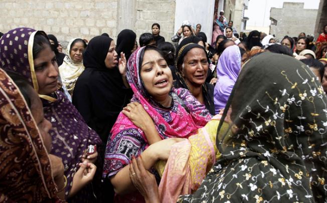 Pakistani women mourn the death of a relatives killed from a fire in a factory in Karachi, Pakistan, on Thursday. Photo: AP