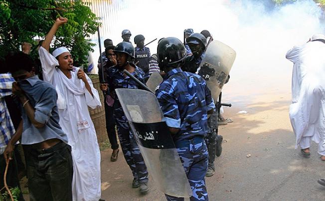 Sudanese policemen try to disperse Muslim protesters outside the German embassy in Khartoum.  Photo: AFP