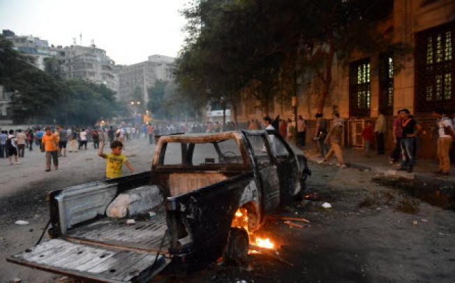 A burnt pick-up truck is seen during clashes between Egyptian protesters and riot police near the US embassy in Cairo on Thursday. Photo: AFP