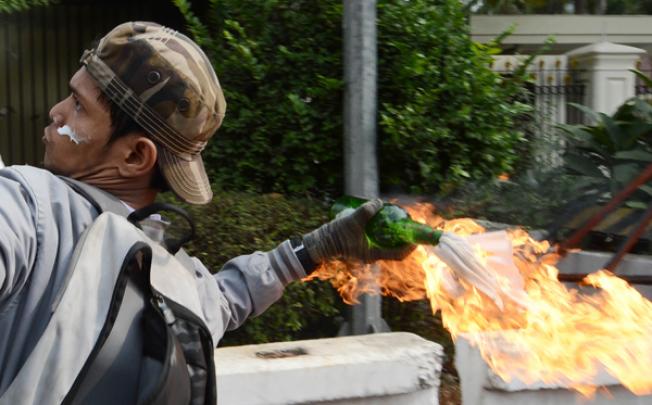 An Indonesian protester hurls a molotov coctail towards the US embassy during a protest on Monday. Photo: AFP