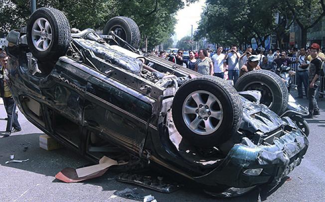 Protesters overturn a Japanese-branded car in Beijing on Saturday. Photo: EPA