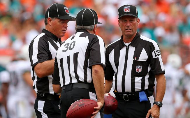 Replacement referees discuss a play during a game. Photo: AFP