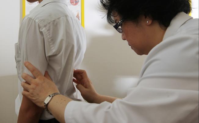 Doctor checks on child suffering back problems because of poor posture. Photo: K.Y. Cheng